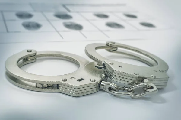 Police Handcuffs on fingerprints crime page file — Stock Photo, Image