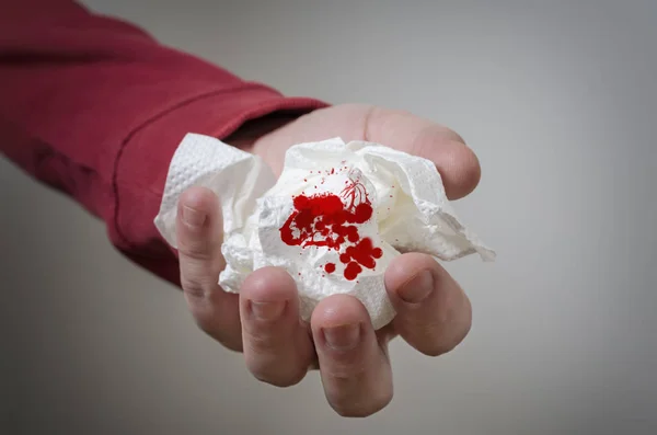 Hand holding a paper handkerchief with blood — Stock Photo, Image