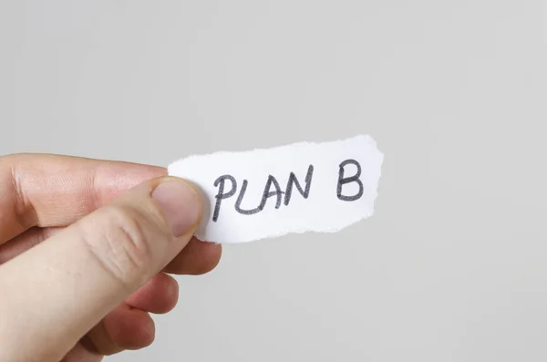 Plan b written on paper in hand