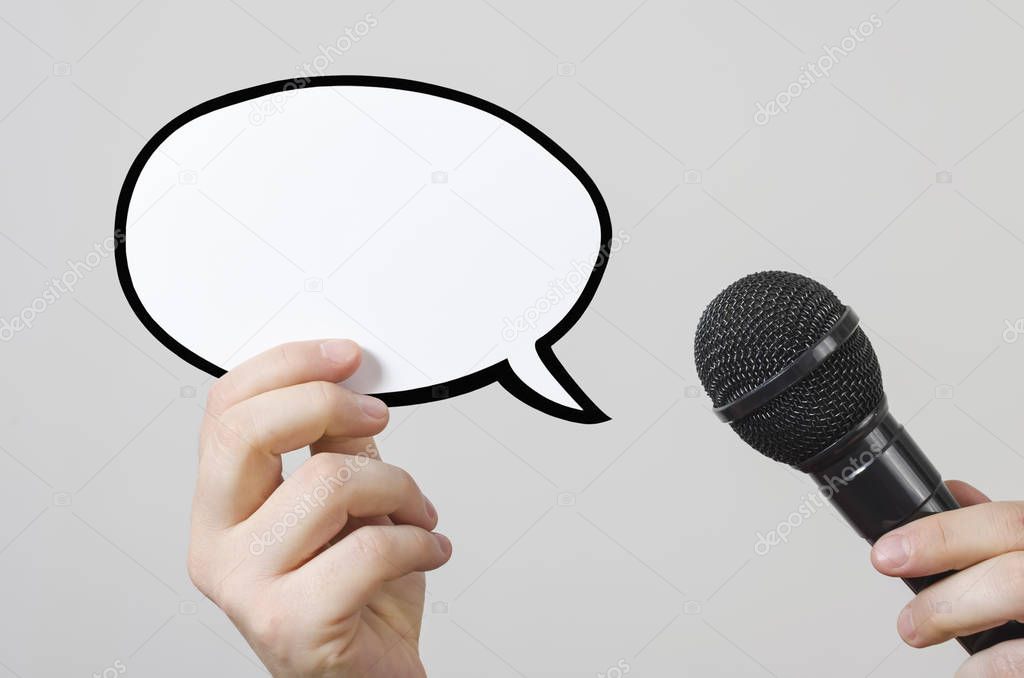 Hands holding a blank speech bubble and microphone
