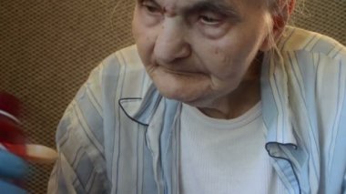 Hasta yaşlı kadın konsantrasyonlu olarak kaşık içinde öksürük şurubu alıyor. Sağlık sigortası konsepti