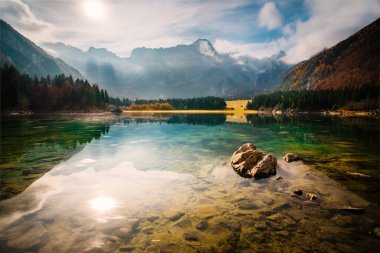 Lago di Fusine 'de kristal berrak su ve arka planda Mangart dağlarıyla güzel bir manzara. Kuzey İtalya 'daki Fusine Gölü' nde sonbahar manzarası - Alpler - Avrupa