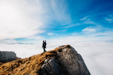 Bir dağın zirvesinde fotoğrafçı maceracı, aktif hayat, iz sürme ve seyahat. Başarı ve özgürlük kavramı.