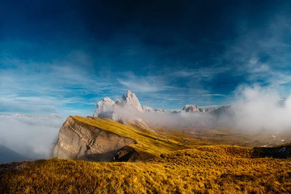 View from Seceda, Odle mountains in the fog, over the clouds. Amazing unique views in Dolomites mountains, Italy, Europe.