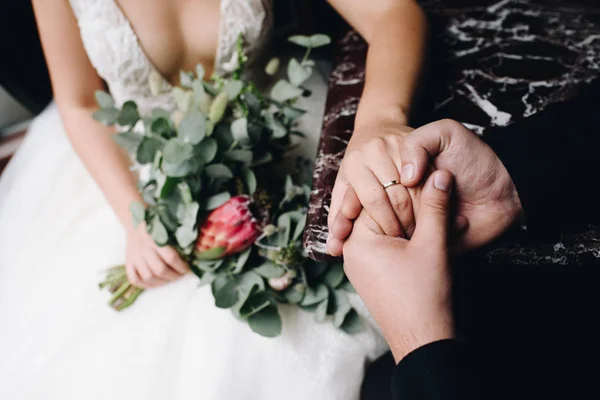 Noiva e noivo sentados juntos de mãos dadas — Fotografia de Stock