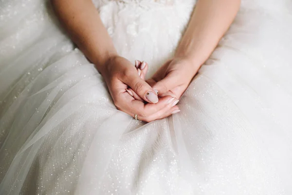 Sposa seduta nel suo abito da sposa, primo piano delle mani — Foto Stock
