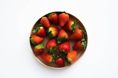 Fresh organic strawberries in a round wooden box, top view