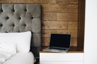 Laptop near bed, working from home in the early morning