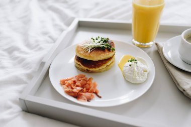 Besleyici ve lezzetli kahvaltı tepside yatakta.