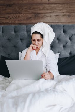 Koronavirüs yüzünden karantina sırasında dizüstü bilgisayarında çalışan beyaz bir iş kadınının dikey görüntüsü.