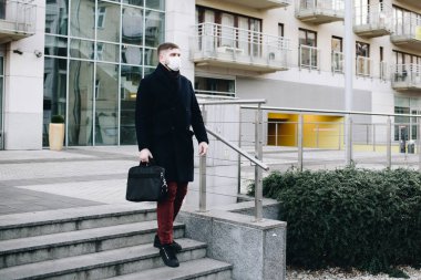 Ofisinin yanındaki yakışıklı beyaz adam Coronavirus covid 19 virüsünden korumak için maske takıyor.