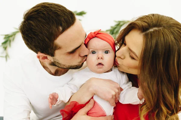 Mamá y papá besando a su linda hija recién nacida — Foto de Stock