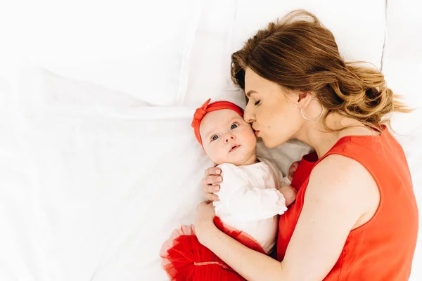 Hermosa mujer caucásica besando a su linda hija bebé con espacio para el texto — Foto de Stock