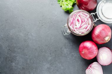 Cam bir kavanozda sirkede doğranmış kırmızı soğan turşusu. Et ve balık yemekleri için lezzetli bir meze. Açık gri arkaplan.