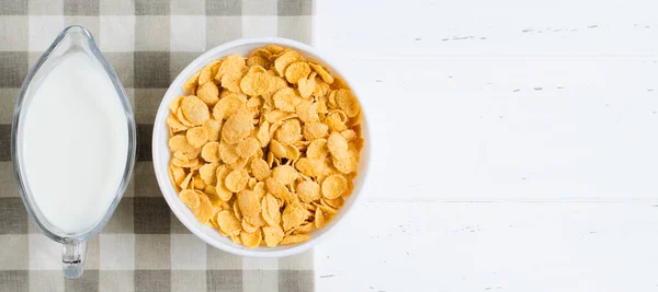 Corn flakes, milk on the tablecloth. Healthy and nutritious Breakfast. White background. Copy space — Stock Photo, Image