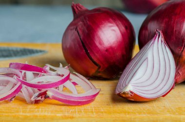 Kırmızı soğan dilimlenmiş. Sarı kesim tahtasında pişirme işlemi