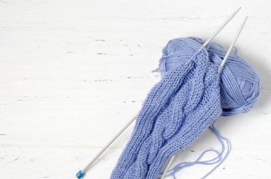 Mavi iplik ve örgü iğnelerinden oluşan toplar. Beyaz arka plan. Uzayı kopyala Kadın nakış işi konsepti..