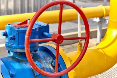 Gaz işleme tesisinde sarı bir borunun mavi vanası var.