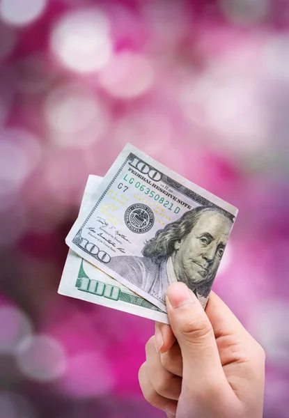 金钱在手 被隔绝在粉红色背景散景 — 图库照片