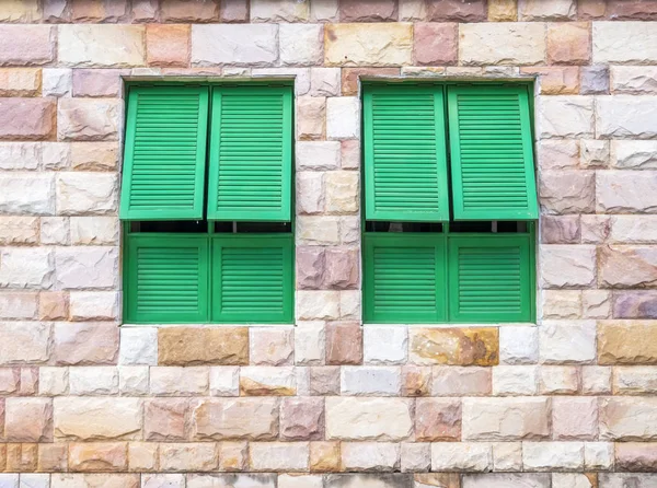 Green window on a brick wall