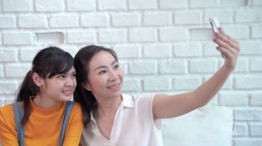 Aile konsepti videosu, Güneydoğu Asyalı anne ve kız mutlu selfie çekiyorlar