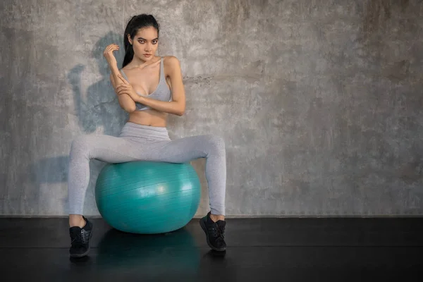 Asiatisches Model Sitzt Auf Einem Yoga Ball Vor Betonwänden Übungs — Stockfoto