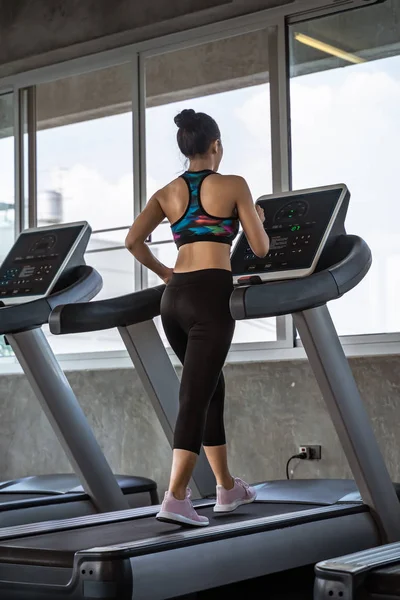 Hermosa asiática chica es caminar en un cinta de correr en la gym.She Se — Foto de Stock