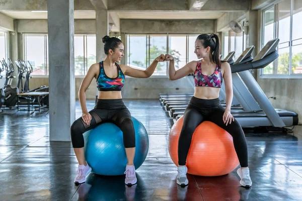 Dos hermosas mujeres asiáticas son fisting su confianza en exerci — Foto de Stock