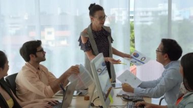 Kadın iş dünyası lideri bir plan sunuyor ve iş ekibinin başarılı olması için beyin fırtınası yapıyor..