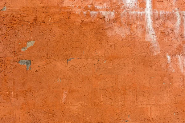 Textured surface of an old orange painted concrete wall
