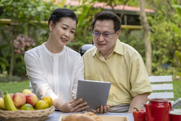 An elderly couple is sitting watching the screen tablet, Concept technology with the elderly