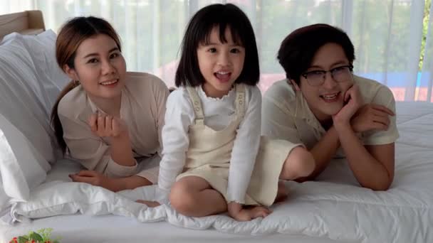 父母们在一个充满快乐和舒适的房子里 把女儿们逗乐在床上 — 图库视频影像