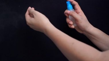 Kara arka planda izole edilmiş veba enfeksiyonunu önlemek için el spreyi kullanımı.