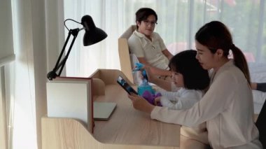 Anne kızına spreyi çeşitli aletleri temizlemek için kullanmayı öğretiyor. Mikroplardan arınmak için evin içinde.