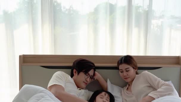 アジアの両親はベッドルームで寝るために彼らの娘を引っ張っている — ストック動画