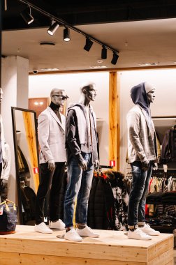 Vitrin vitrininde mankenler giymiş bir kadın ve erkek vardı. Giyinik mankenlerle dolu butik penceresi.