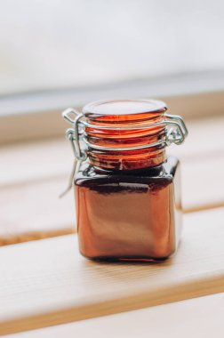 Bir kozmetik koyu kehribar cam şişe ve ahşap masa üzerinde beyaz kepçe. Yakın çekim, telif uzayı. Güzellik blogu, kuaför tedavisi konsepti