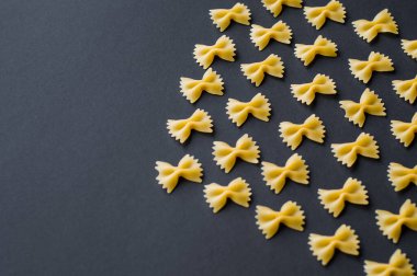 Mavi arka planda İtalyan makarna deseni. Yukarıdan çeşitli renkte papyon farfalle makarna görünüyor. Üst görünüm. 