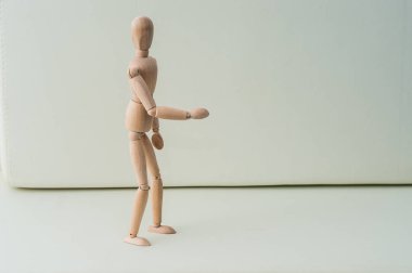 Gri arka planda elleri kalçasında tahta kukla