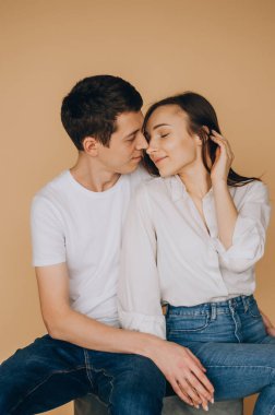 Beyaz tenli, uzun sarı saçlı, kırmızı seksi elbiseli, yüksek topuklu ve gri arka planda duran esmer, otoriter bir adamın güzel bir çift portresi. Aşk ve tutku kavramı