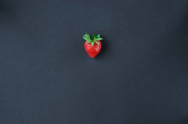 Sebzeler ve meyveler aynı renkte, mavi üzerine izole edilmiş taze çileklerin üst görüntüsü.