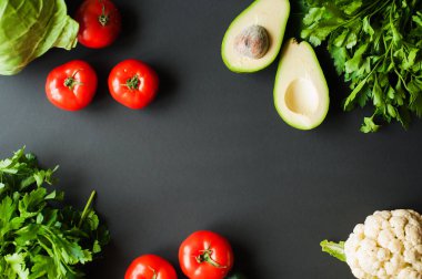 Çiğ organik sebzeler ve siyah arka planda sağlıklı pişirmek için taze malzemeler. Vegan ya da diyet gıda konsepti. Ücretsiz metin spac ile arkaplan düzeni