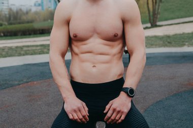 Stüdyoda poz veren kaslı vücutlu seksi bir genç adam portresi. Gri arka plan. Erkek Sağlığı.