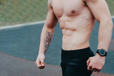 Stüdyoda poz veren kaslı vücutlu seksi bir genç adam portresi. Gri arka plan. Erkek Sağlığı.