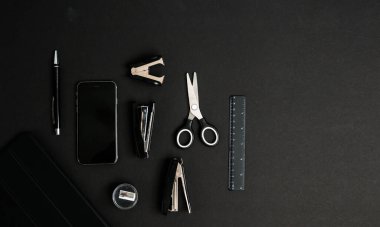 Modern bir masada ofis malzemeleri ve iş aletlerinin karışımı.