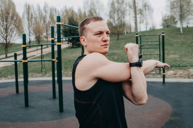 Formda sporcu stadyumda egzersiz yapıyor. Şehrin parkındaki beyaz bir genç adam. Spor egzersizlerini göster. Spor, spor, sağlık, yaşam tarzı konsepti