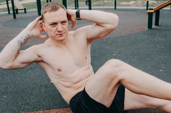 Muskularny Mężczyzna Robi Ćwiczenia Mięśni Brzucha Podniesionymi Nogami Zdjęcie Treningu — Zdjęcie stockowe