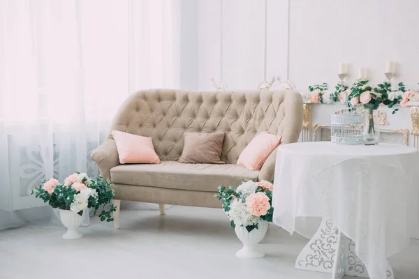 Schöne Weiße Raumausstattung Mit Rosa Blumen Und Dekorativem Sofa — Stockfoto