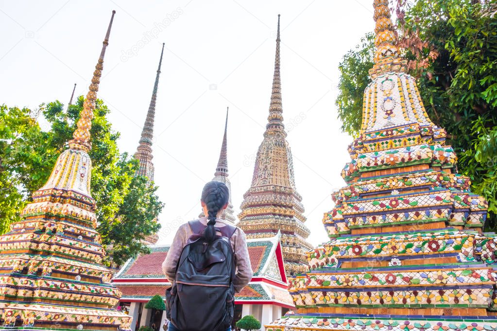 Asian woman backpack tourist is relax travel in holiday at wat pho Bangkok Thailand. It is a landmark and attraction.