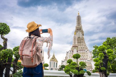 Asyalı kadın turist sırt çantası ile bir fotoğraf veya smartphone ile selfie bir seyahat sırasında alma ve sakin tatil pagoda arun, tapınak bir dönüm noktası ve Bangkok Tayland ilgi öyle.